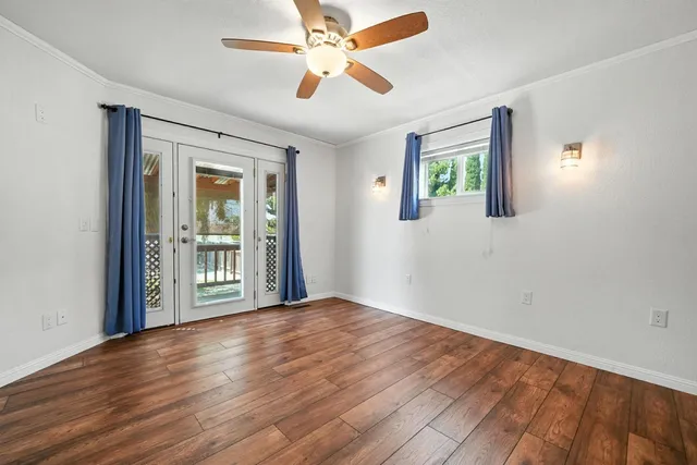 a view of a room with a ceiling fan and wooden floor