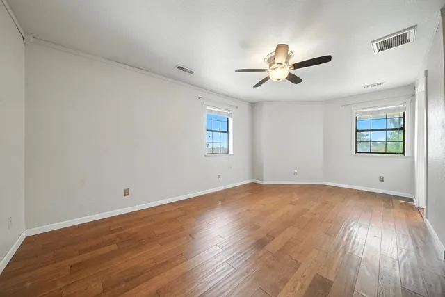 a view of an empty room with wooden floor