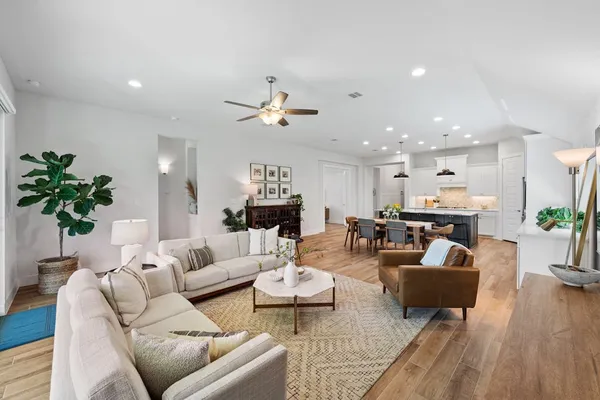 a living room with furniture flat screen tv and a large window