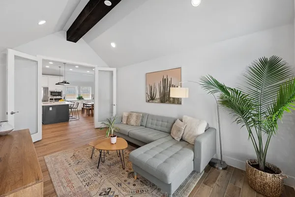 a living room with furniture kitchen view and a potted plant