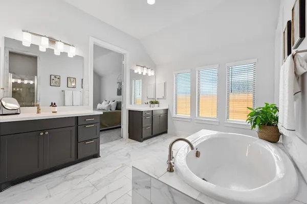 a white bath tub sitting in a bathroom next to a window