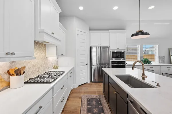 a kitchen with stainless steel appliances a sink stove and refrigerator