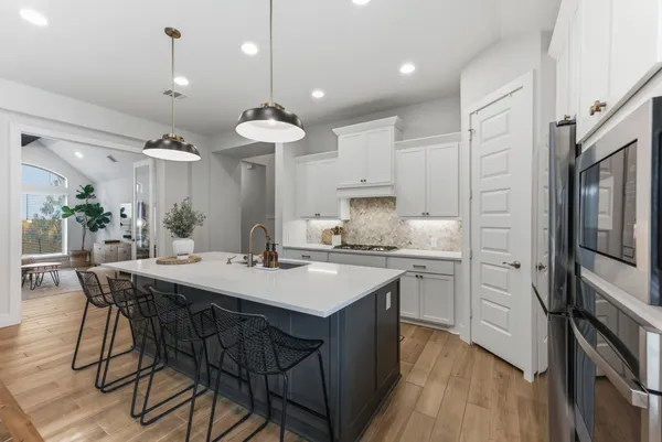 a kitchen with kitchen island granite countertop a sink a center island stainless steel appliances and cabinets