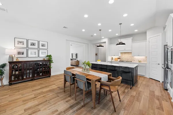 a kitchen with stainless steel appliances kitchen island granite countertop a table and chairs in it