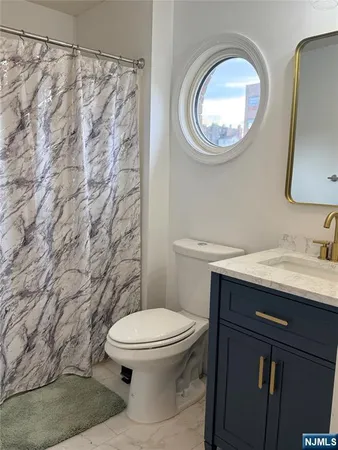 a bathroom with a granite countertop toilet sink and mirror