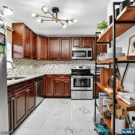 a kitchen with stainless steel appliances granite countertop a stove and cabinets