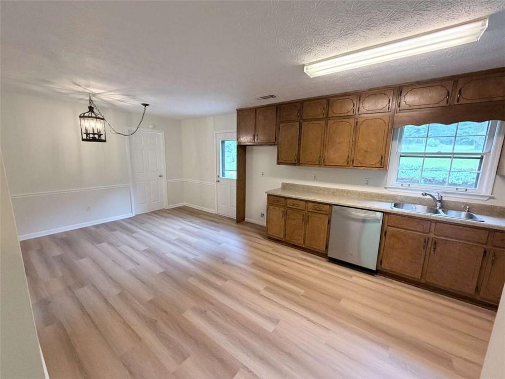 185 Roberts Road Covington, GA 30016 - Photo 13 of 25 a kitchen with stainless steel appliances granite countertop a sink cabinets wooden floor and a window