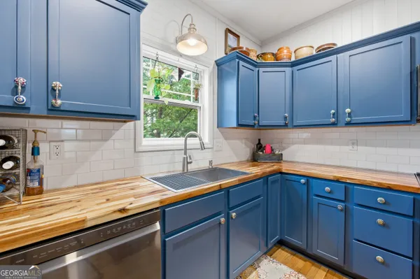 a kitchen with granite countertop stainless steel appliances a sink window and cabinets