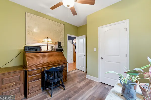 a living room with a table chairs and a refrigerator