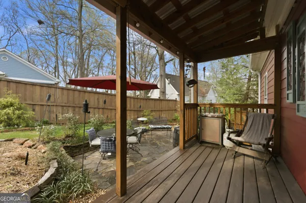a view of a patio with chairs and table under an umbrella