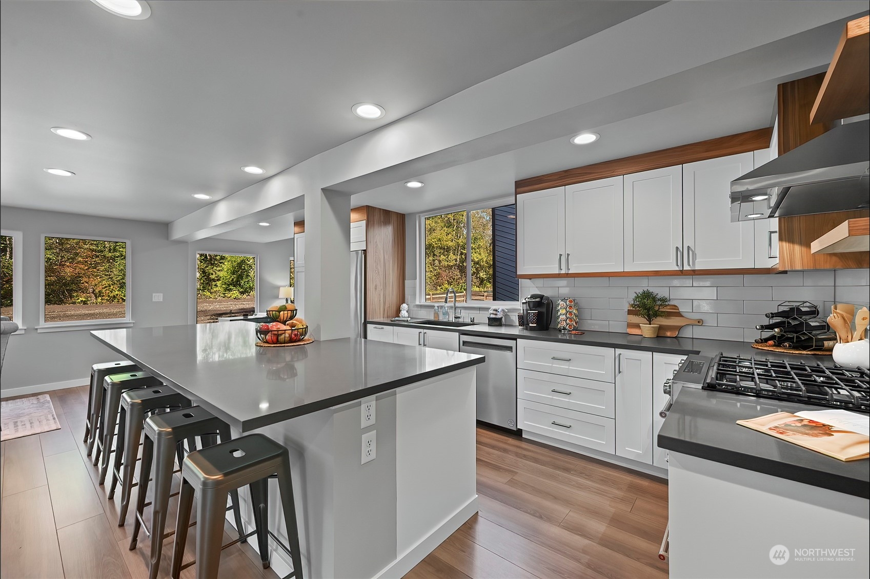 23026 30th Drive Southeast Bothell, WA 98021 - Photo 9 of 40 a kitchen with stainless steel appliances granite countertop a stove a sink a refrigerator and white cabinets with wooden floor
