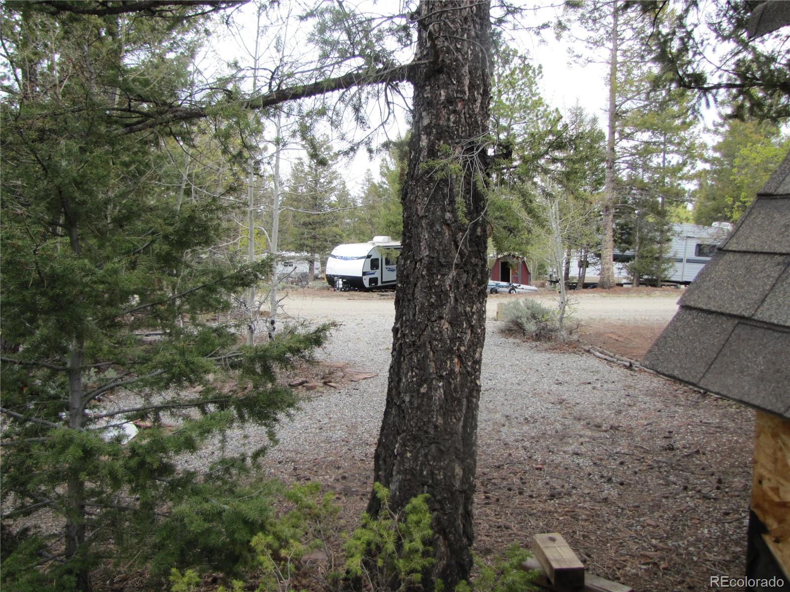 60 Rail Way Fairplay, CO 80440 - Photo 7 of 18 a backyard of a house with large trees and wooden fence