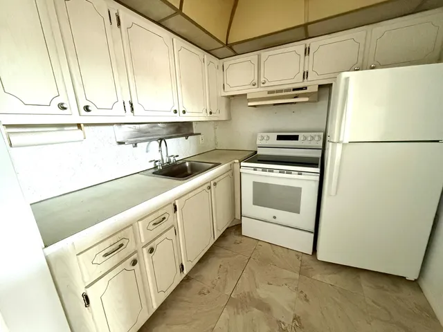 a kitchen with stainless steel appliances a refrigerator sink and cabinets