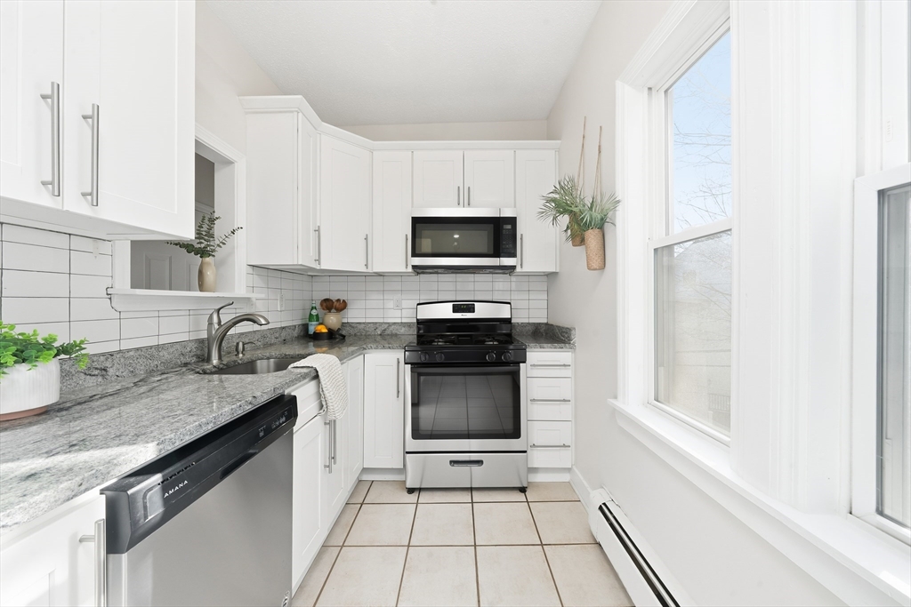 8 Humboldt Avenue, Unit 2 Boston, MA 02119 - Photo 21 of 39 a kitchen with granite countertop a stove sink and microwave