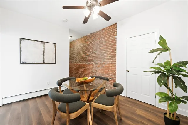 a dining room with furniture and potted plants