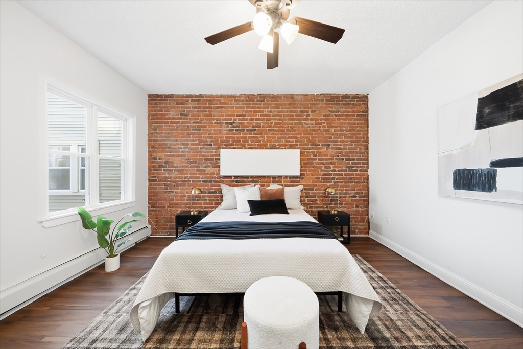 8 Humboldt Avenue, Unit 2 Boston, MA 02119 - Photo 5 of 39 a bed sitting in a bedroom next to a window with potted plants
