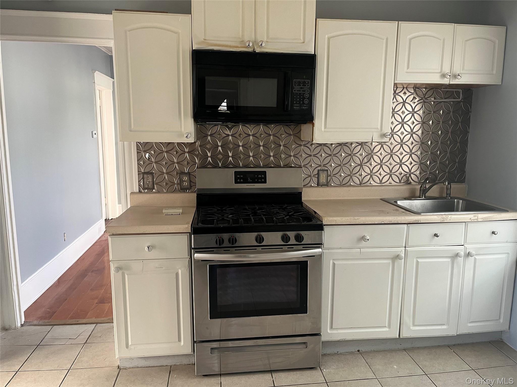 a kitchen with granite countertop white cabinets and stainless steel appliances