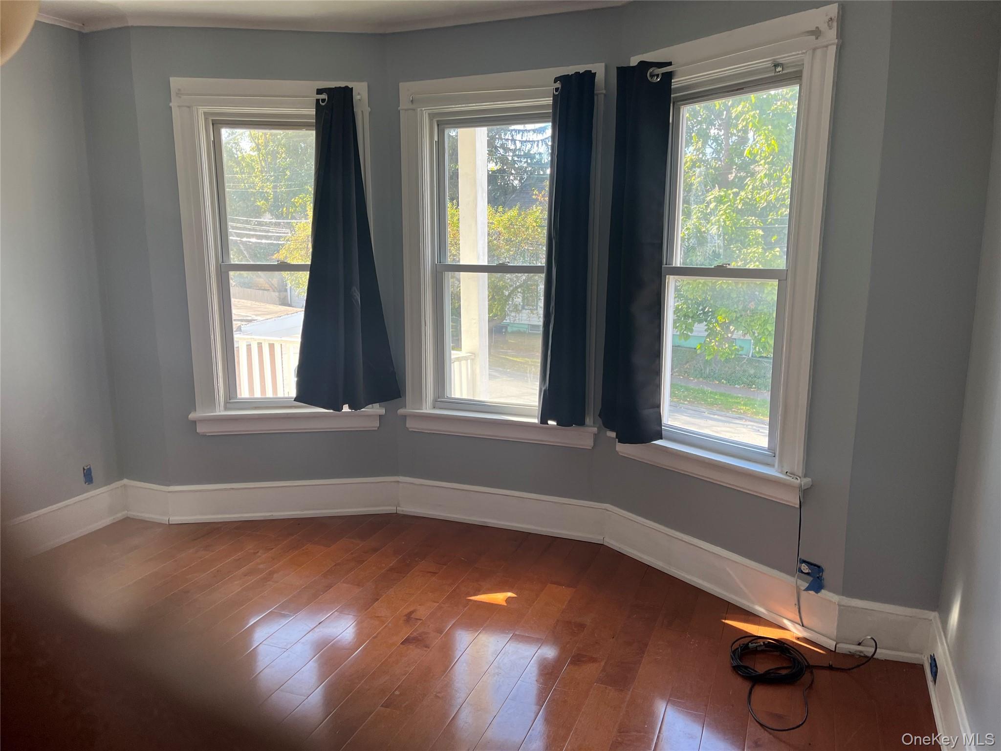 107 Smith Street, Unit 2 Poughkeepsie, NY 12601 - Photo 7 of 9 a view of an empty room with wooden floor and a window