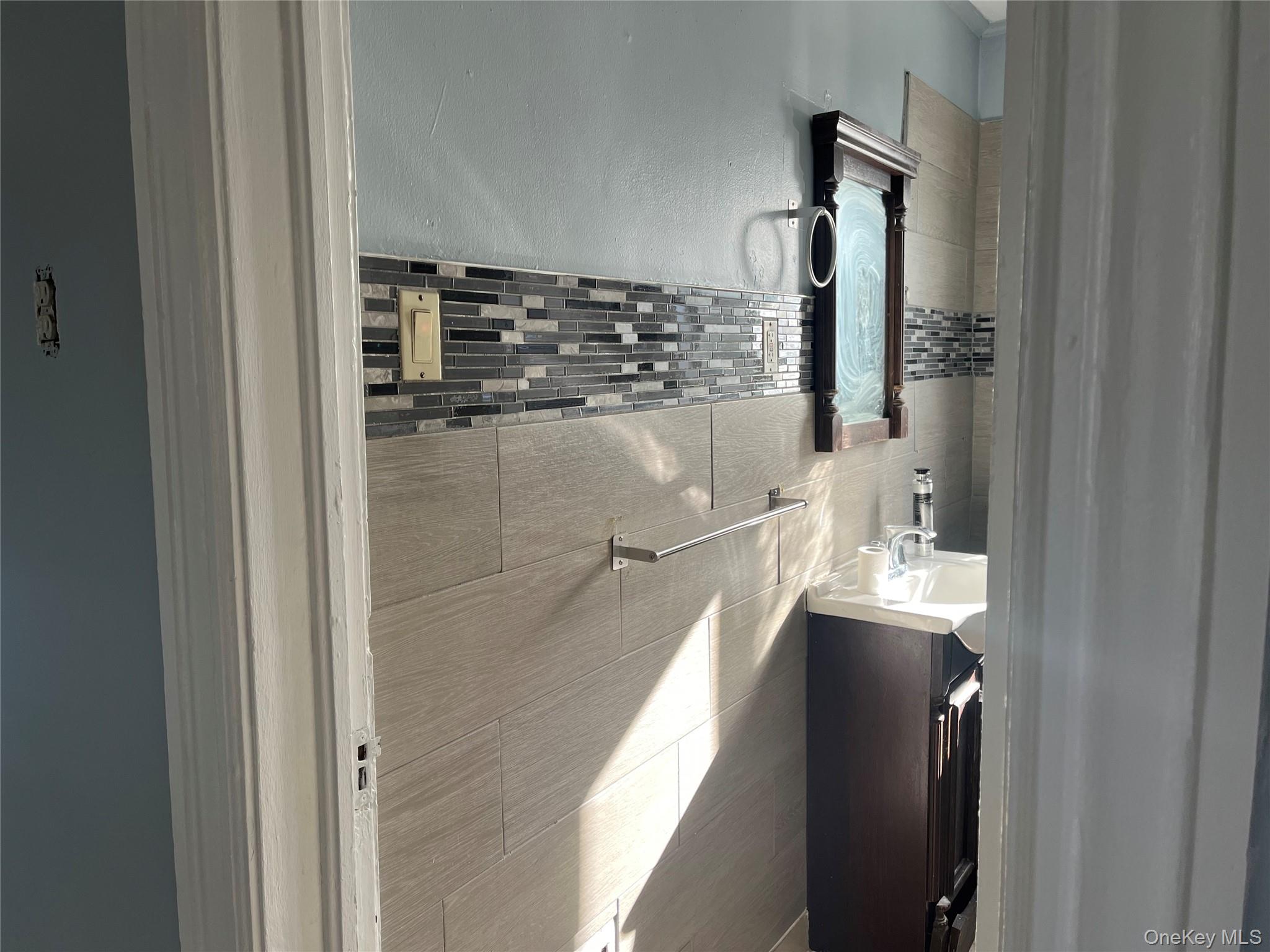 107 Smith Street, Unit 2 Poughkeepsie, NY 12601 - Photo 8 of 9 a en suite bathroom with a granite countertop shower a sink and a mirror