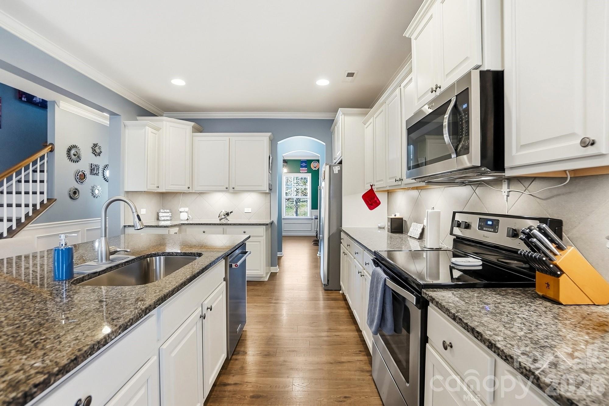 1103 Clover Lane Matthews, NC 28104 - Photo 11 of 46 a kitchen with stainless steel appliances granite countertop a sink stove and refrigerator