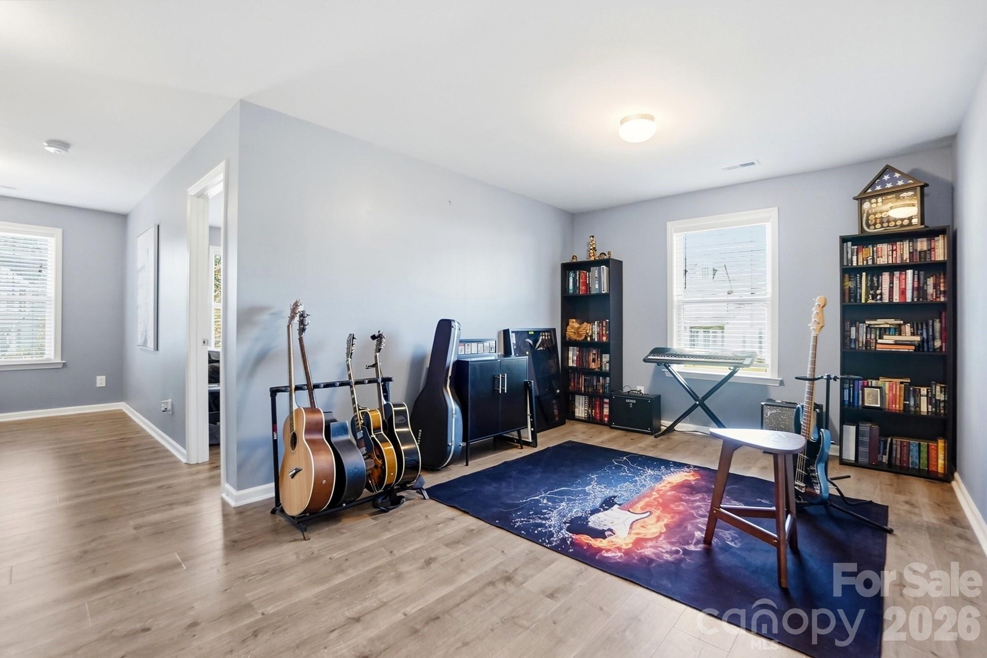 1103 Clover Lane Matthews, NC 28104 - Photo 34 of 46 a living room with furniture a bookshelf and a wooden floor
