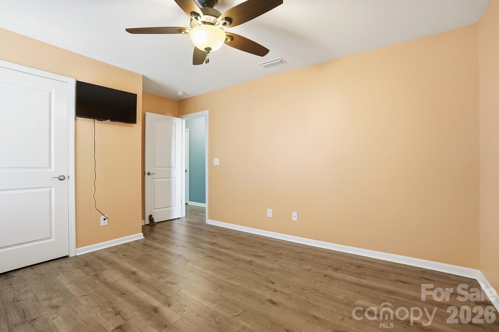 1103 Clover Lane Matthews, NC 28104 - Photo 37 of 46 an empty room with wooden floor ceiling fan and windows