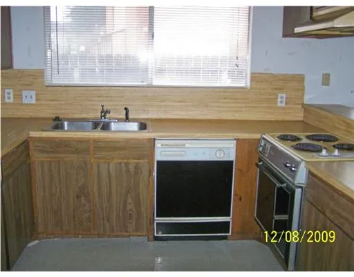a kitchen with granite countertop a sink a stove and a microwave