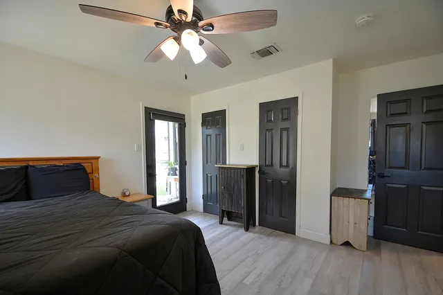 a bedroom with a bed and a flat tv screen on dresser