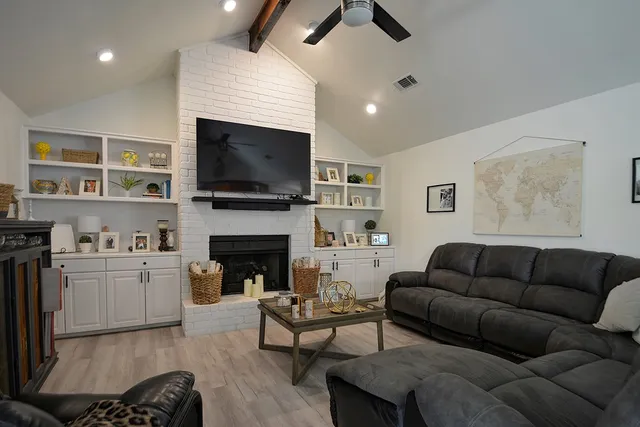 a living room with furniture a fireplace and a flat screen tv