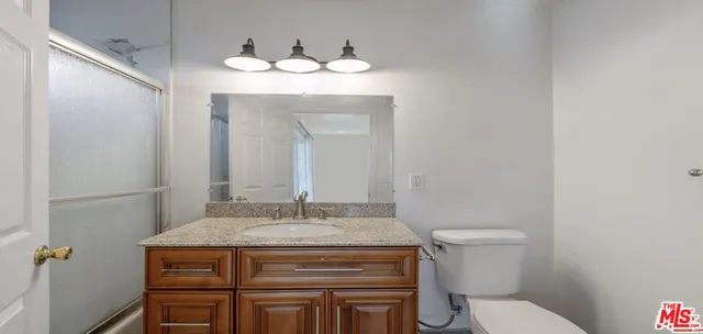 a bathroom with a toilet sink and mirror
