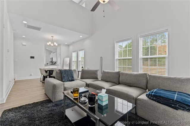a view of a dining room with furniture a chandelier and wooden floor