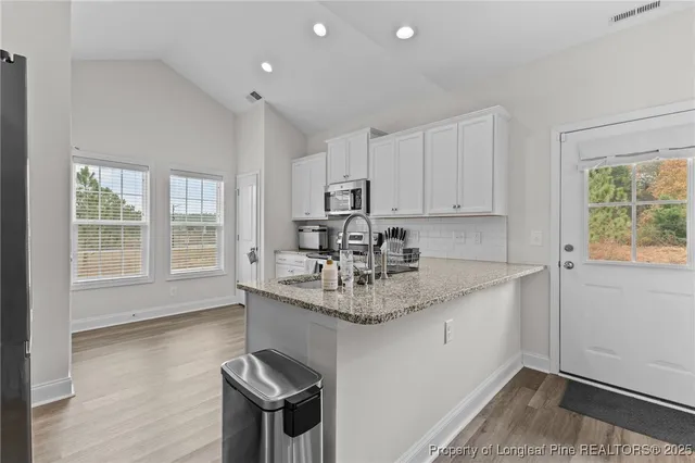 a kitchen with sink refrigerator and large window
