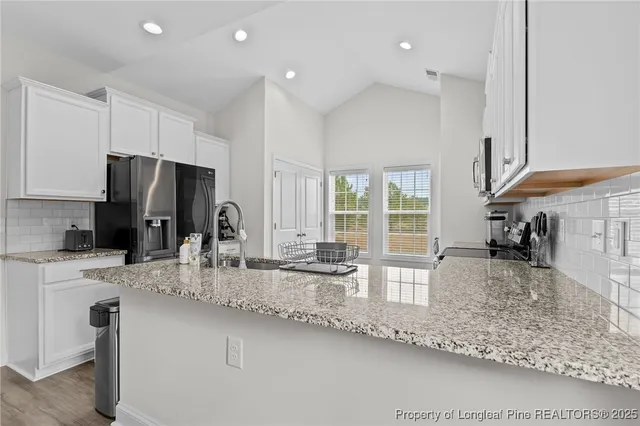 a kitchen with stainless steel appliances granite countertop a stove a sink and a microwave