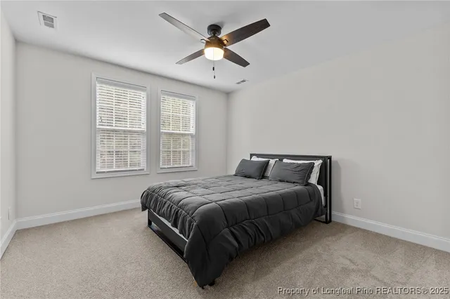 a bed sitting in a bedroom next to a window