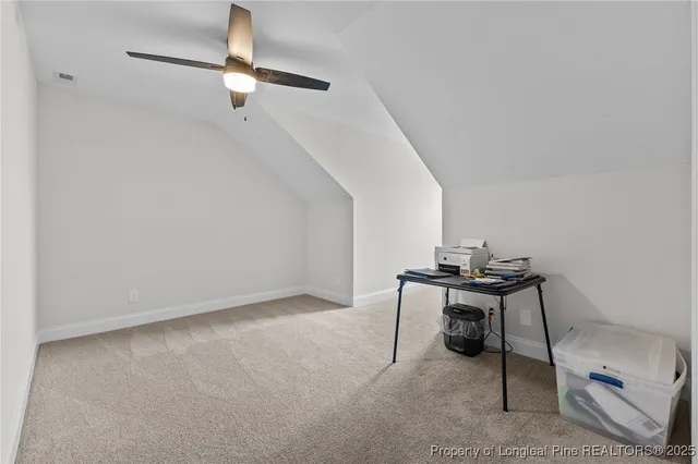 an empty room with chandelier fan and windows