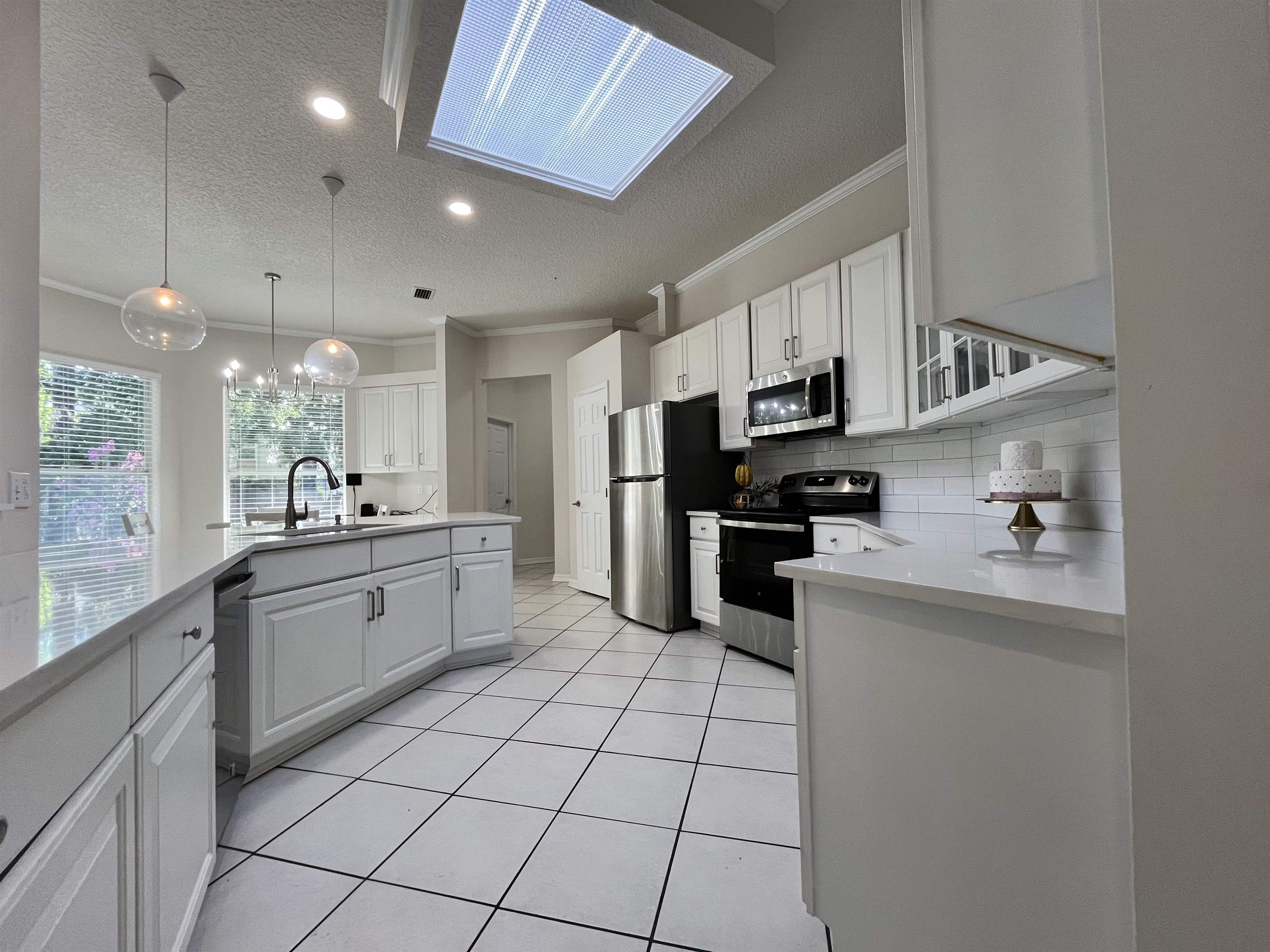 9606 Melvina Road Jacksonville, FL 32257 - Photo 13 of 23 Kitchen with crown molding, white cabinetry, stainless steel appliances, tasteful backsplash, and a textured ceiling