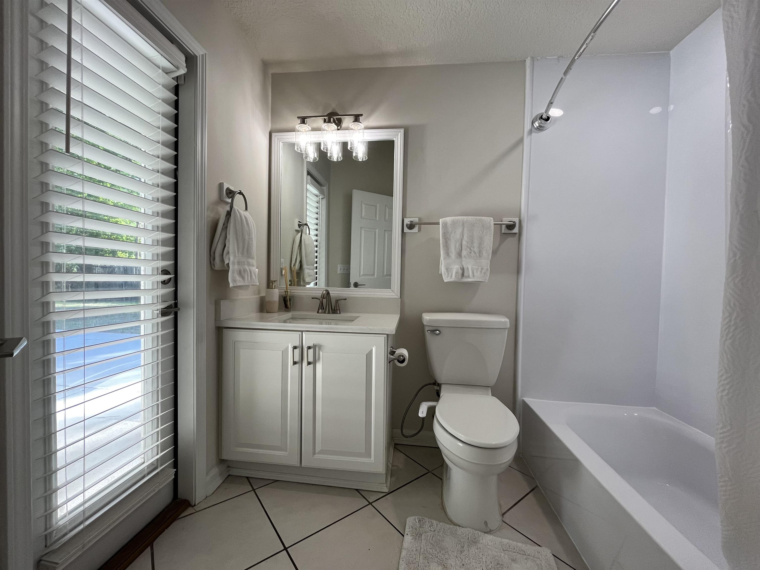9606 Melvina Road Jacksonville, FL 32257 - Photo 16 of 23 Bathroom with light tile patterned floors, vanity, a textured ceiling, and washtub / shower combination
