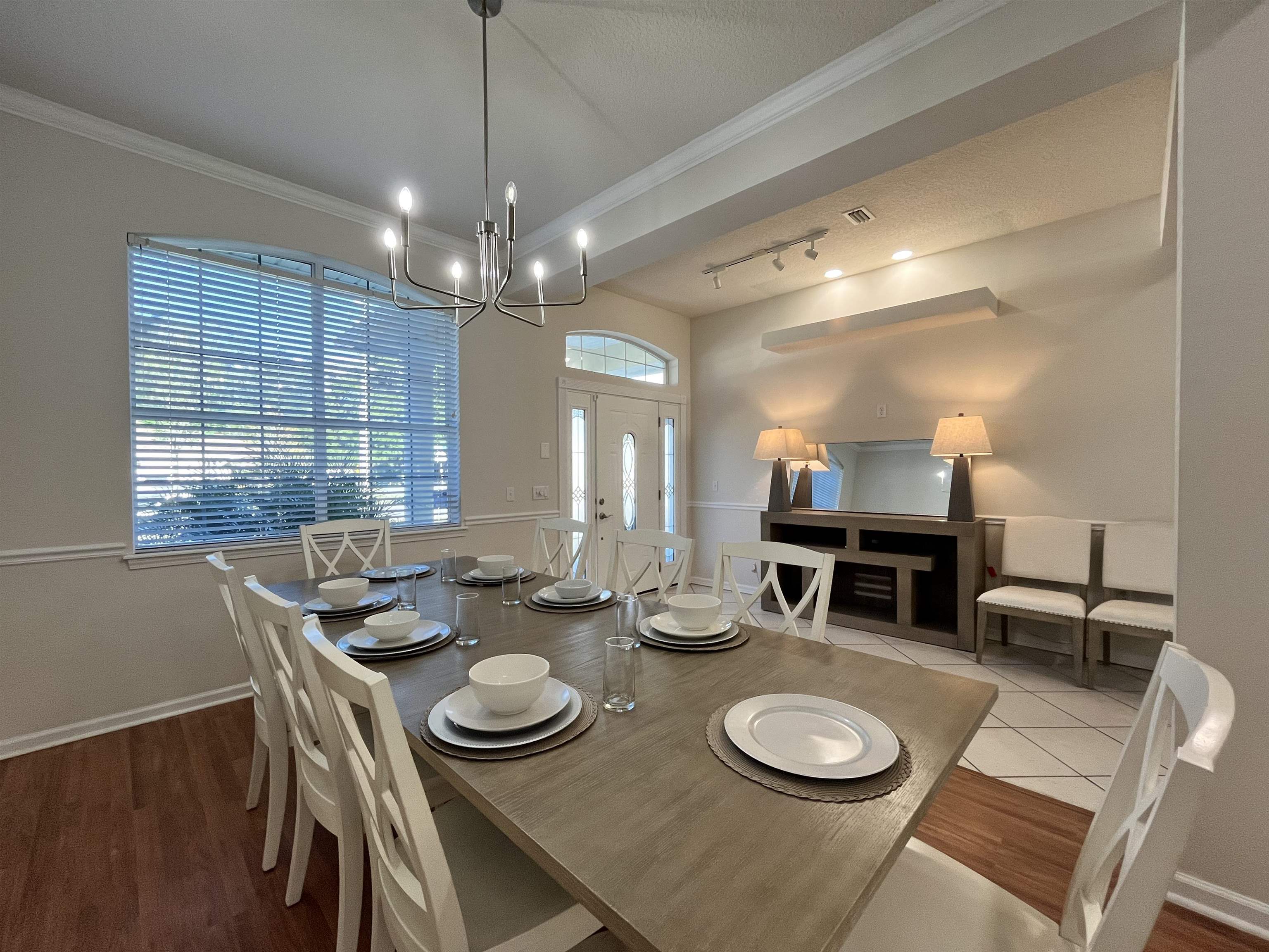 9606 Melvina Road Jacksonville, FL 32257 - Photo 2 of 23 Dining space featuring wood finished floors, rail lighting, ornamental molding, and a chandelier