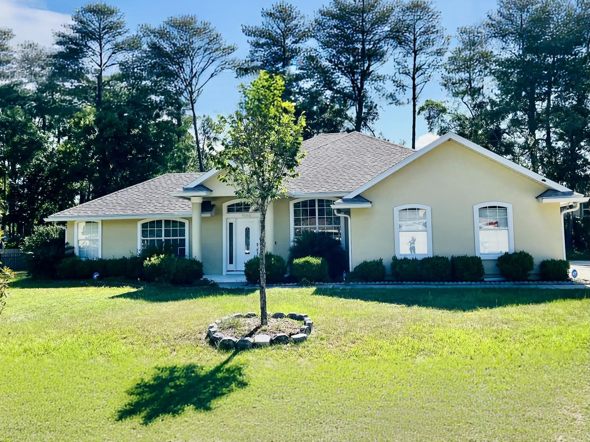 9606 Melvina Road Jacksonville, FL 32257 - Photo 22 of 23 Single story home with roof with shingles, a front lawn, and stucco siding