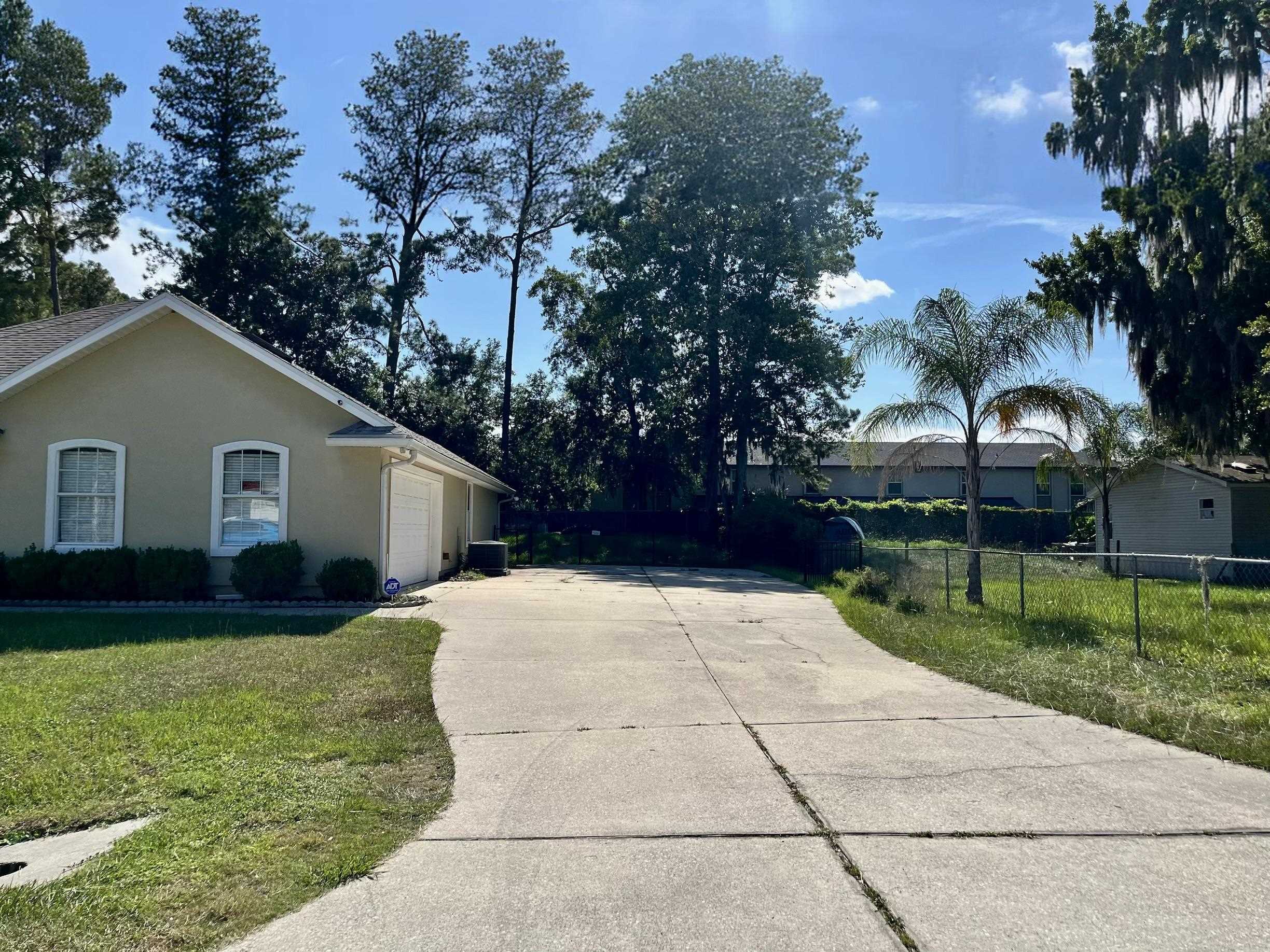 9606 Melvina Road Jacksonville, FL 32257 - Photo 23 of 23 View of side of property featuring a garage, stucco siding, and concrete driveway