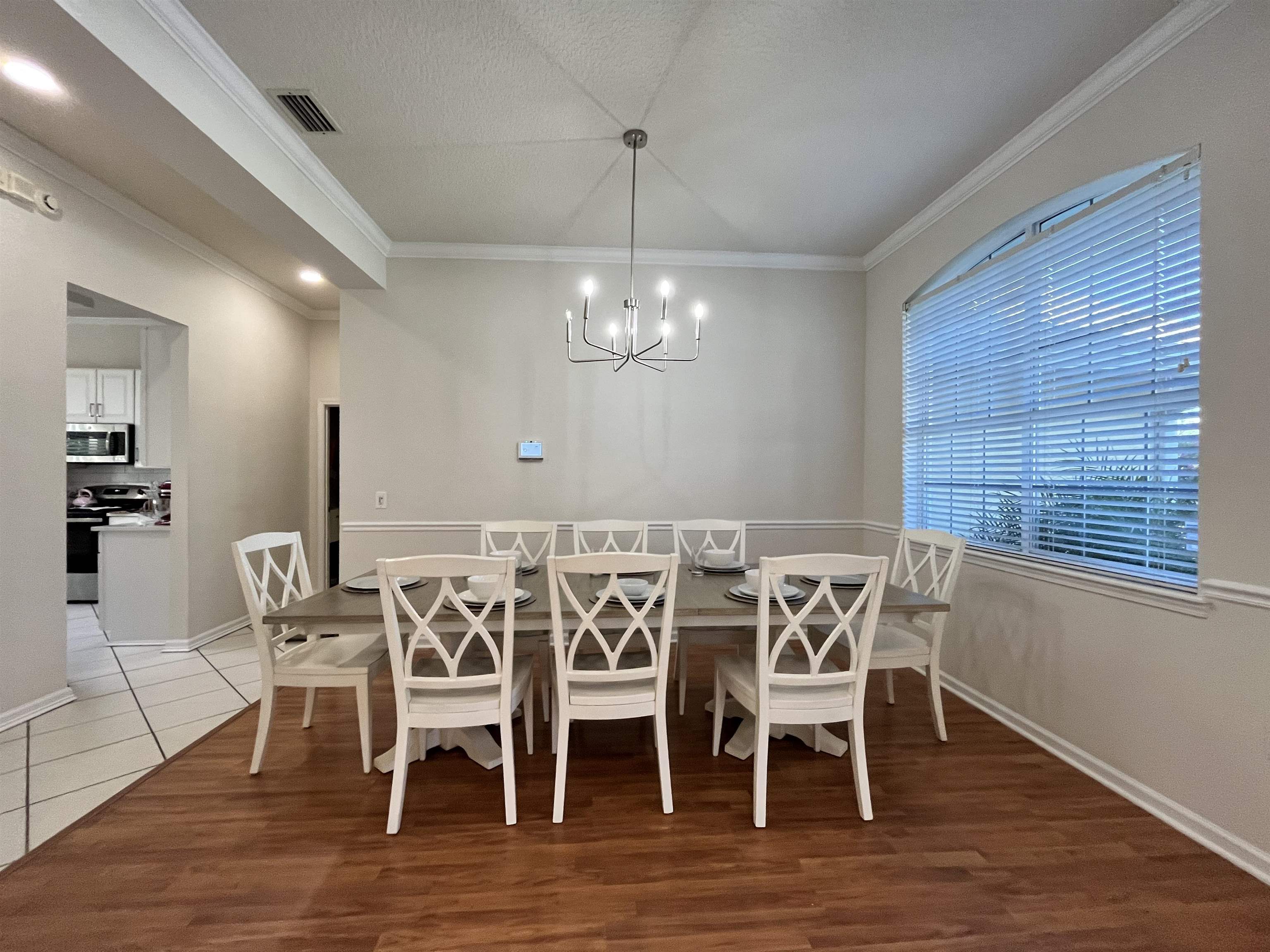 9606 Melvina Road Jacksonville, FL 32257 - Photo 4 of 23 Dining space with ornamental molding, a chandelier, light wood-style floors, and a textured ceiling