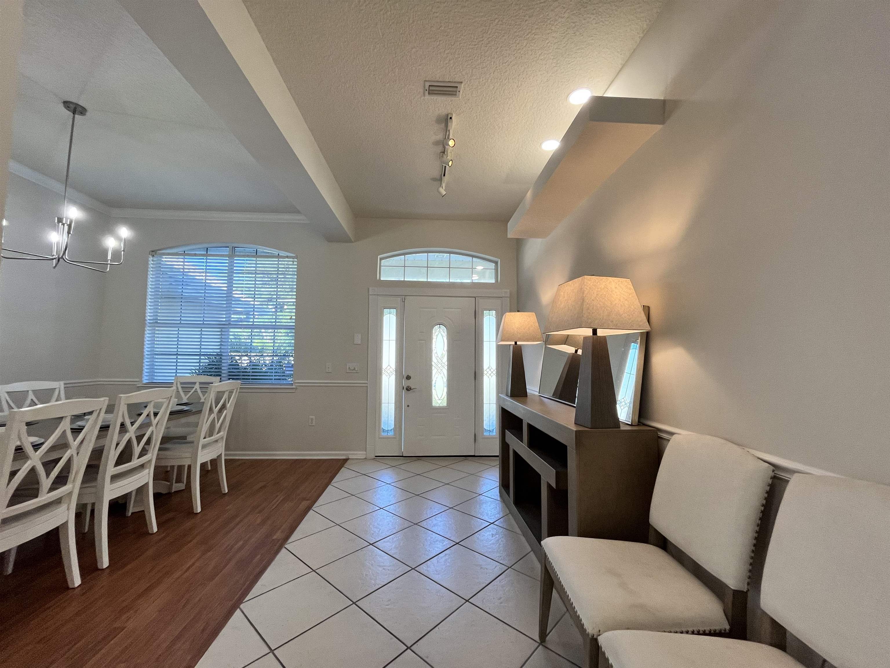9606 Melvina Road Jacksonville, FL 32257 - Photo 6 of 23 Entrance foyer featuring light tile patterned floors, beamed ceiling, a textured ceiling, and a chandelier
