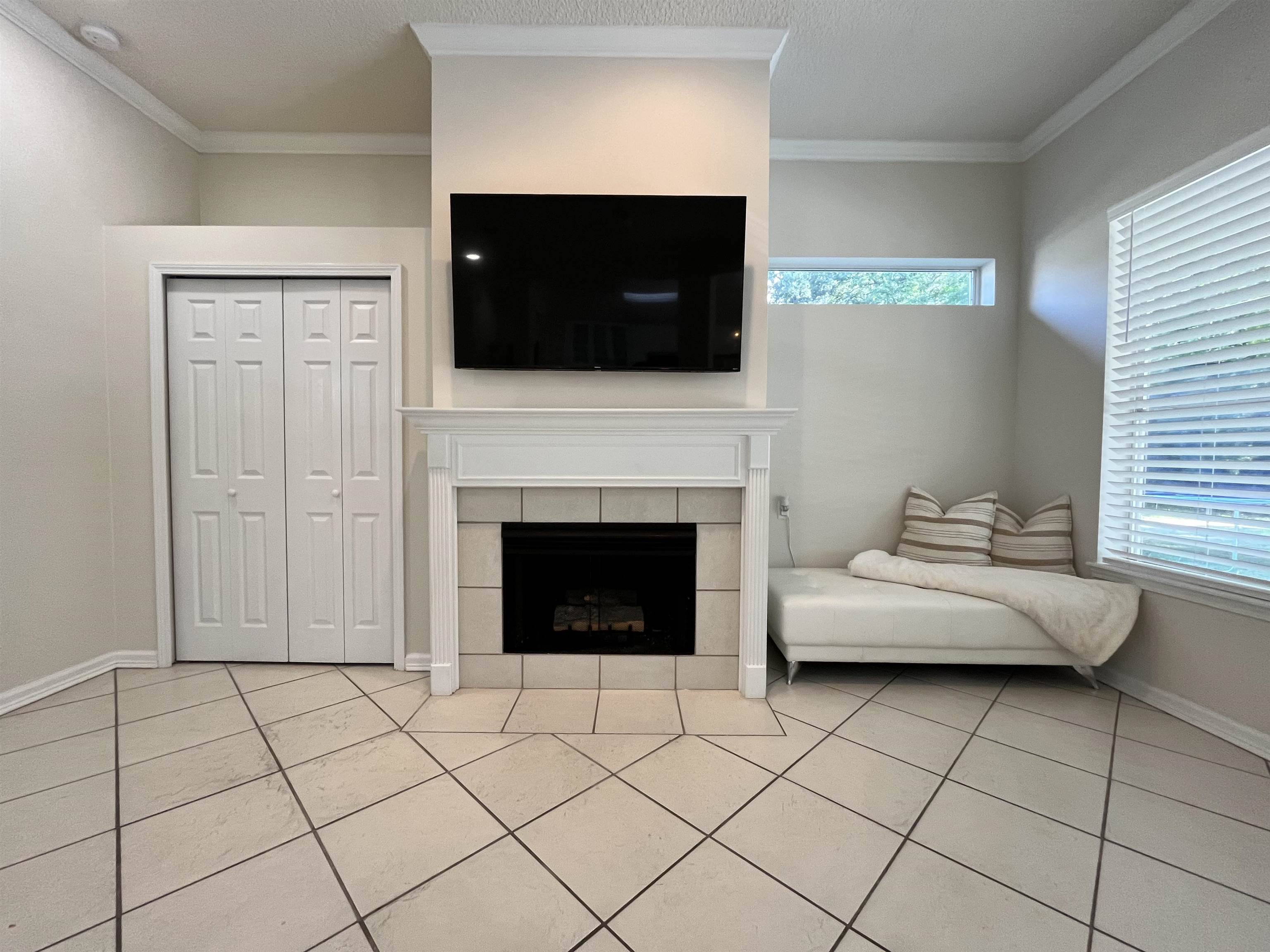 9606 Melvina Road Jacksonville, FL 32257 - Photo 9 of 23 Living room with crown molding, light tile patterned flooring, and a fireplace