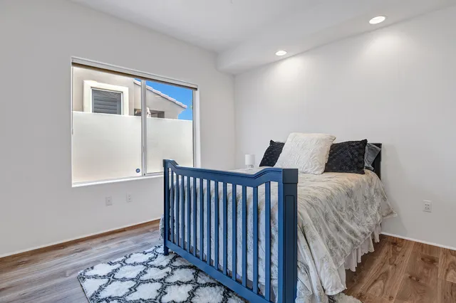 a bedroom with bed and wooden floor