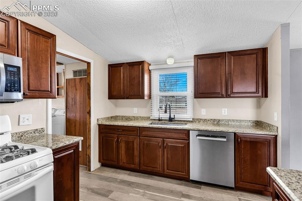1044 P Street Penrose, CO 81240 - Photo 15 of 48 a kitchen with stainless steel appliances granite countertop a stove a sink dishwasher and a refrigerator