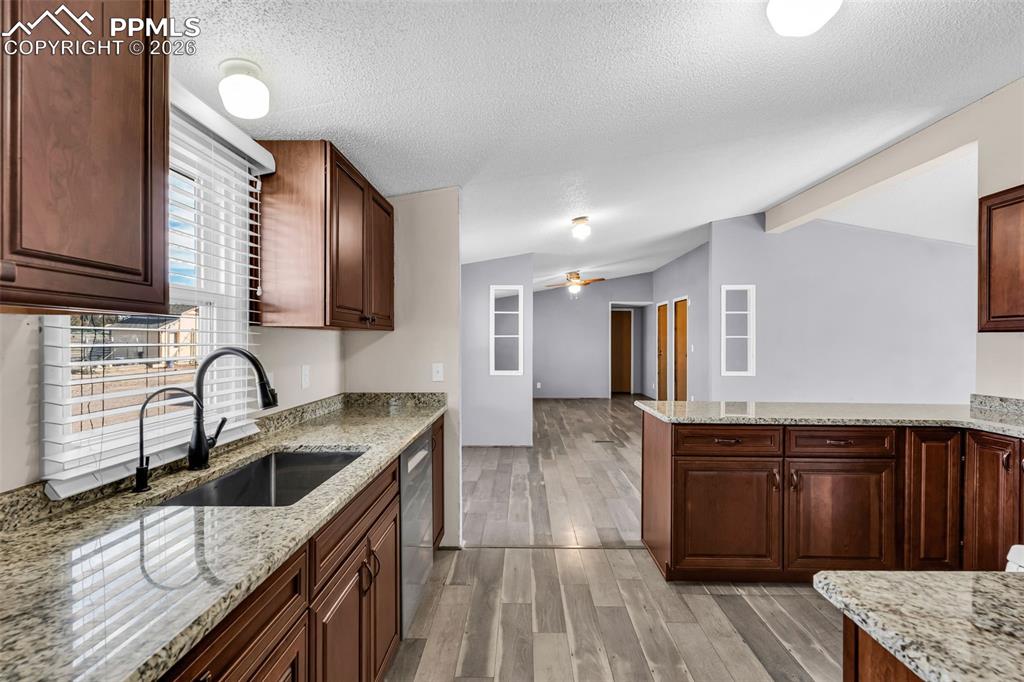1044 P Street Penrose, CO 81240 - Photo 16 of 48 a kitchen with granite countertop a sink wooden cabinets and stainless steel appliances
