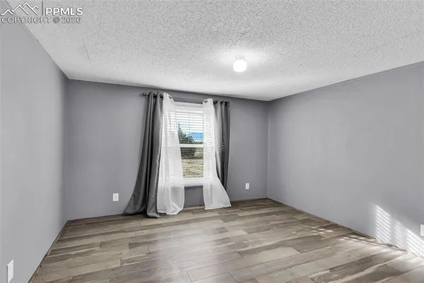 a view of an empty room with closet and a window