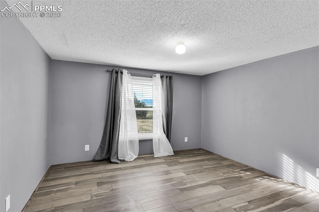 1044 P Street Penrose, CO 81240 - Photo 21 of 48 an empty room with wooden floor and windows