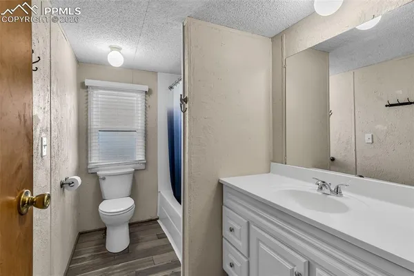 an empty room with window and ceiling fan