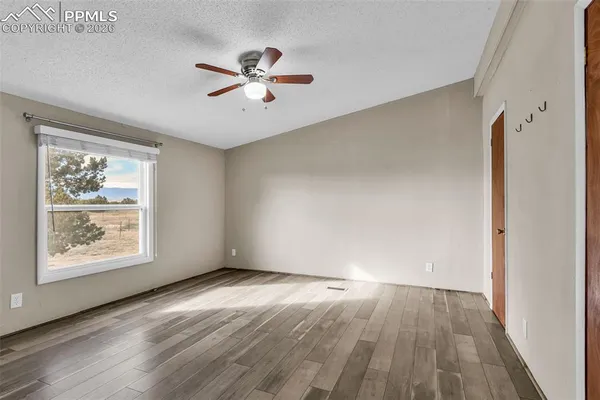 an empty room with closet and a ceiling fan